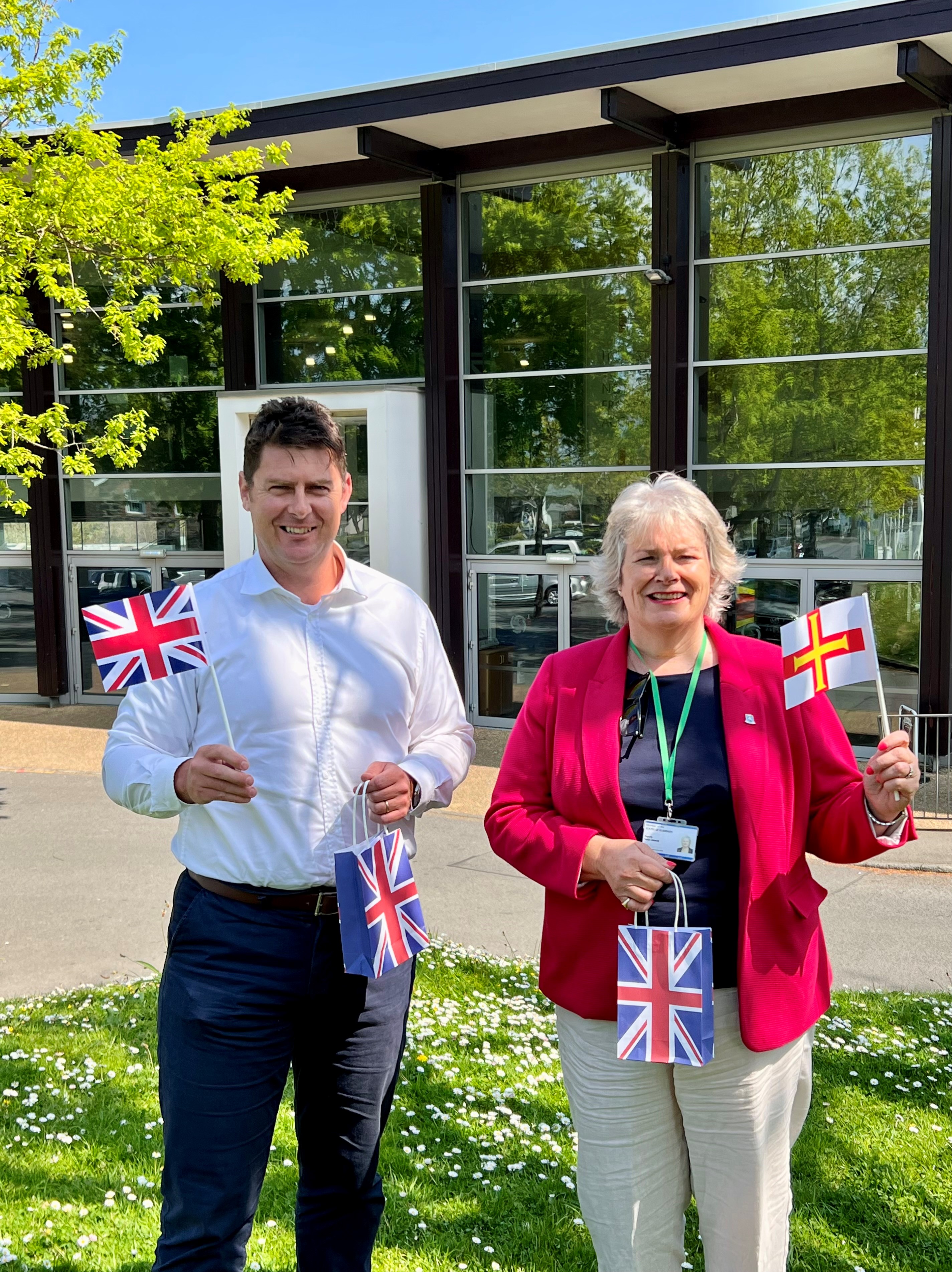Sue Aldwell joined by Glen Tonks of Credit Suisse pictured outside Beau Sejour Leisure Centre holding their activity packs and biodegradable flags.